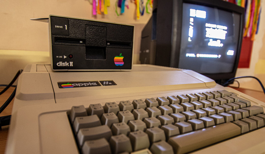 Apple IIe z napędem Disk II i monitorem kineskopowym na stanowisku do retro grania